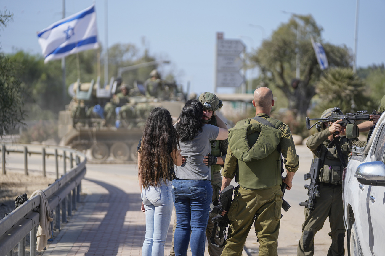 An Israeli soldier receives a surprise visit from his mother and his partner near the border with the Gaza Strip, southern Israel, Friday, Oct. 20, 2023. The Israeli military has beefed up ground forces near the Gaza Strip ahead of an expected ground invasion as the latest war between Israel and Hamas militants completes its second week. (AP Photo/Ohad Zwigenberg)