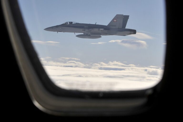 A FA18 Hornet from the Swiss Army flies next to a civil plane during an excercise of air policing near Davos in Switzerland, Monday, January 24, 2011. About 4000 Swiss soldiers will take part in the security operation called 