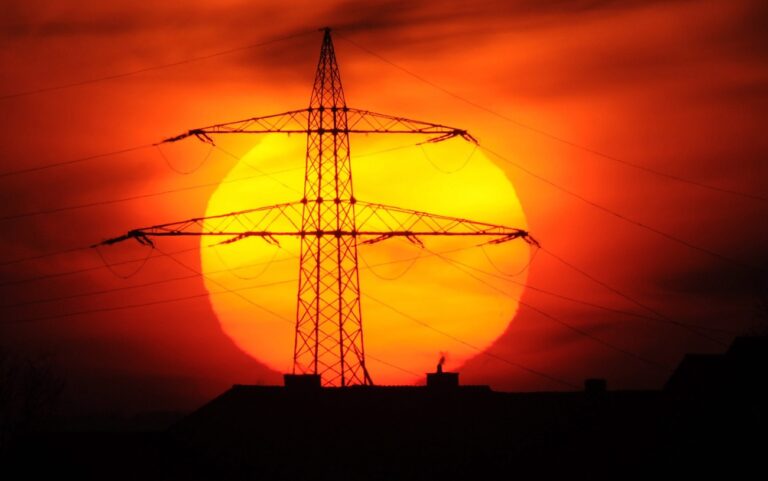 epa03095102 The sun sets behind a power line near Laatzen, Germany, 06 February 2012. Due to a growth in wind and sun energy supply, Germany barely suffers from power outages during extremely cold winters. According to a representative of the German Ministry of the Environment, the increase in wind and solar power has payed off. The four major power suppliers already assured consumers that Germany will not suffer outages during the cold weather. EPA/JULIAN STRATENSCHULTE