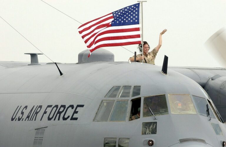Senior Airman Katheryn Quimby, of the 182nd Airlift Wing of the Illinois Air National Guard, holding the United States flag waves while arriving at the Peoria Air Guard base Thursday, 14 August 2003, in Peoria, Ill. Quimby returned to Peoria with a large contingent of military personnel from the unit's participation in Operation Iraqi Freedom. (KEYSTONE/EPA/DECATUR HERALD AND REVIEW/CARLOS T. MIRANDA)