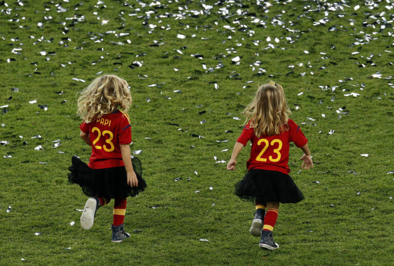 Two girls wearing shirts with the number of Spain goalkeeper Pepe Reina run over the pitch after Spain won the Euro 2012 soccer championship final between Spain and Italy in Kiev, Ukraine, Monday, July 2, 2012. (AP Photo/Vadim Ghirda)