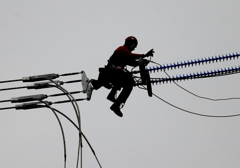 A worker is silhouetted as he mounts the new overhead electric power lines at a high altitude in Dortmund, Germany, Monday, Nov. 5, 2012. 3,600 km (2,237 miles) of new power cables are planned in Germany to force the energy turnaround to use alternative sources. The German utilities' industry association BDEW said Monday the solar power output from January through September rose from 16.5 gigawatt hours last year to 25 gigawatt hours in 2012. Germany decided last year to phase out nuclear power by 2022 and replace it with renewable energies. (AP Photo/Frank Augstein)