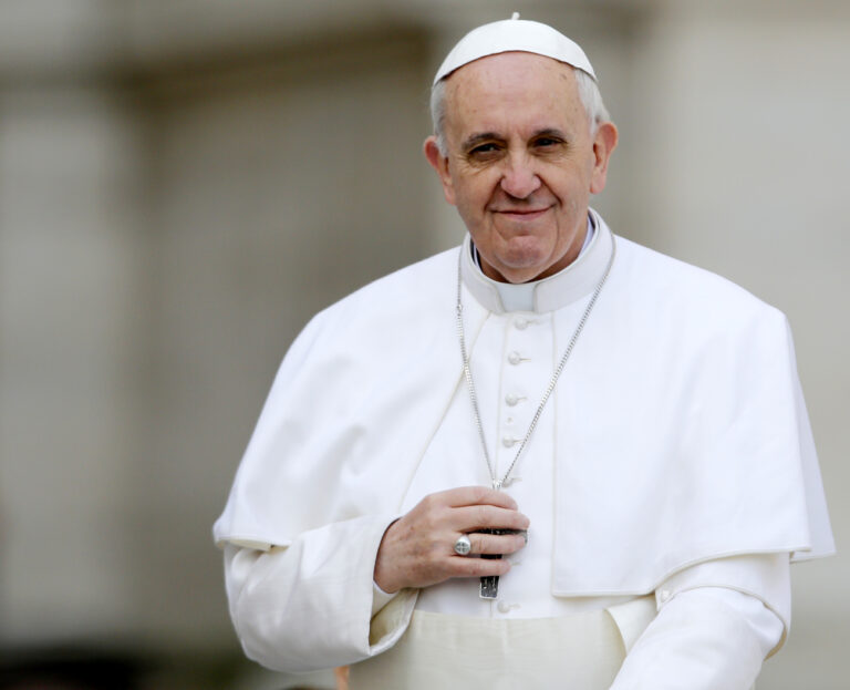 Pope Francis touches his cross as he is driven through the crowd during his general audience, in St. Peter's Square, at the Vatican, Wednesday, March 27, 2013. (AP Photo/Andrew Medichini)