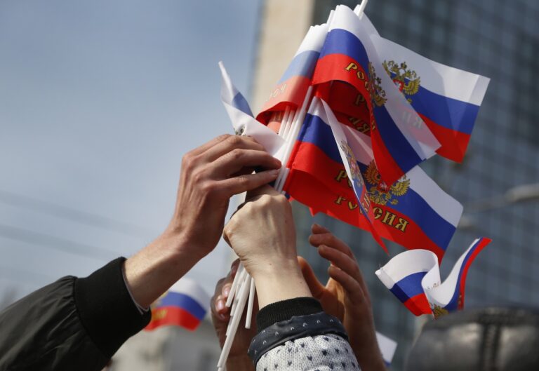 Protestors taking Russian flags during a pro Russian rally with Russian state flags at a central square in Donetsk, eastern Ukraine, Saturday, March 15, 2014. Russian forces backed by helicopter gunships and armored vehicles Saturday took control of a village near the border with Crimea on the eve of a referendum on whether the region should seek annexation by Moscow, Ukrainian officials said. (AP Photo/Sergei Grits)
