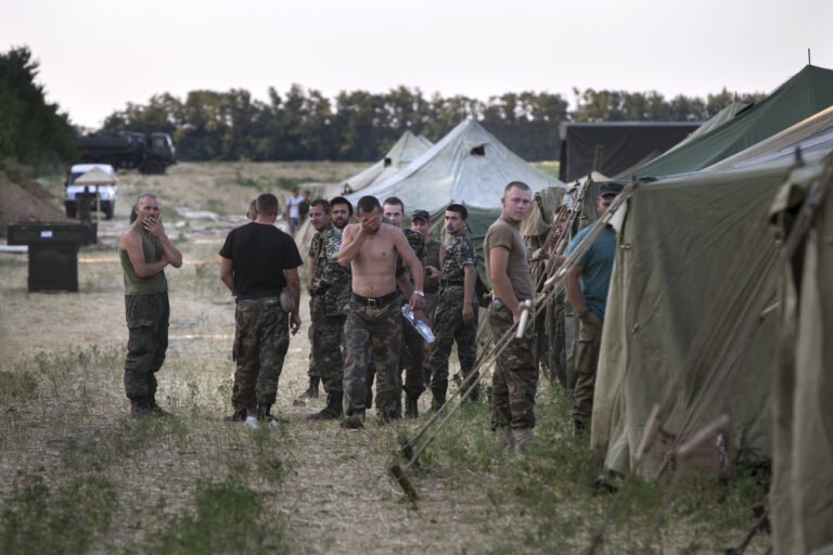 Ukrainian soldiers, who fled the conflict territory, spend their time at a tent camp near the Russia-Ukraine border just outside the village of Gukovo, Rostov-on-Don region, southern Russia, Monday, Aug. 4, 2014. A Russian border security official said Monday that more than 400 Ukrainian soldiers have crossed into Russia. The Russian official said the soldiers deserted the Kiev government and the Russian side opened a safe corridor. (AP Photo/Alexander Zemlianichenko)