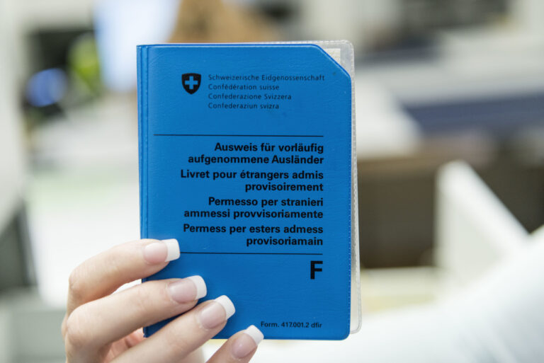 An employee of the residents' registration office in Schaffhausen, Switzerland, holds a foreign national identity card, pictured on October 7, 2014. (KEYSTONE/Christian Beutler)