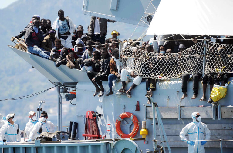 Migrants wait to disembark from the Italian Navy vessel 'Chimera' in the harbor of Salerno, Italy, Wednesday, April 22, 2015. Italy pressed the European Union on Wednesday to devise concrete, robust steps to stop the deadly tide of migrants on smugglers' boats in the Mediterranean, including setting up refugee camps in countries bordering Libya. Italian Defense Minister Roberta Pinotti also said human traffickers must be targeted with military intervention. (AP Photo/Francesco Pecoraro)
