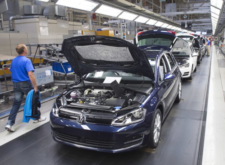 Workers complete cars at the assembly line during the so called 'Open Door Day' to celebrate the 25th anniversary of the German manufacturer Volkswagen Sachsen in Zwickau, eastern Germany, Sunday, Sept. 6, 2015. More than 4.9 Million vehicles (Golf and Passat) have left the production facilities since foundation on the Zwickau plant in 1990. (AP Photo/Jens Meyer)
