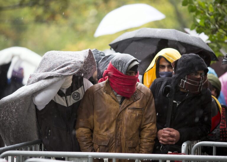 epa04977100 Refugees wait in cold temperatures for registration and the allocation of sleeping places at the State Office for Health and Social Affairs (LaGeSo) in Berlin, Germany, 14 October 2015. Germany officially expects around 800,000 asylum seekers in 2015. The record waves of migrants streaming across its borders has led some to question Chancellor Angela Merkel's decision to loosen asylum laws and allow in more refugees from war zones like Syria and Afghanistan. The treacherous journey will become even more arduous with the onset of winter. EPA/KAY NIETFELD