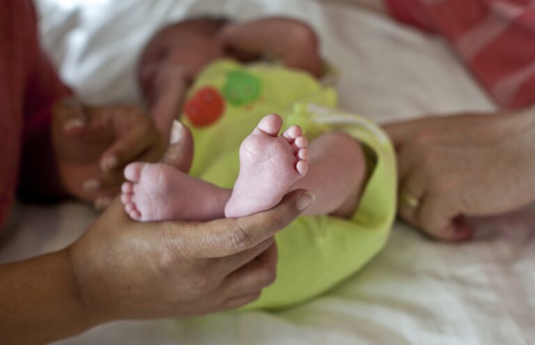 In this Nov. 5, 2015 photo, a couple from Britain whose baby was born on Oct. 17 by a surrogate pose their baby for a photo in Anand, India. For 15 years the couple were unable to get pregnant and turned to Dr Nayna Patel's clinic after seeing her on a TV program. (AP Photo/Allison Joyce)