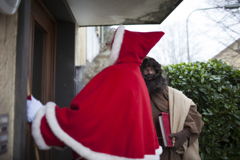 Ein Samichlaus der St. Nikolausgesellschaft der Stadt Zuerich und sein Schmutzli klopfen vor einem Besuch an die Haustuere, aufgenommen am 6. Dezember 2015 in Zuerich. (KEYSTONE/Petra Orosz)