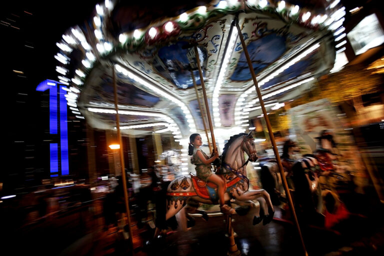In this April 22, 2015 photo, a girl enjoys riding a carousel horse at the Marina waterfront in Dubai, United Arab Emirates. Dubai's year-round sunshine gives the Marina a summer-vibe throughout the winter months, when temperatures rarely drop below a comfortable 75 degrees Fahrenheit (24 Celsius) during the day. (AP Photo/Kamran Jebreili)
