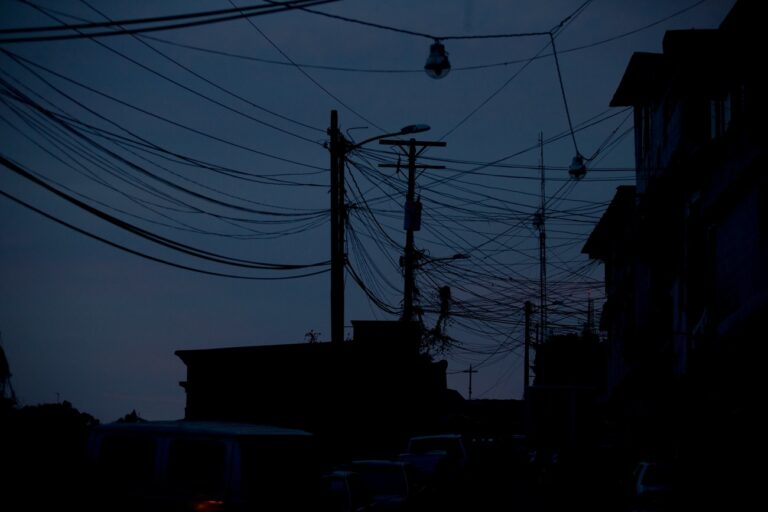 This Saturday, April 23, 2016 photo shows electrical cabling silhouetted against a darkening sky a 24-hour blackout, in the El Calvario neighborhood of El Hatillo, just outside of Caracas, Venezuela. Energy rationing has been added to the hardships faced by Venezuelans overwhelmed by inflation, shortages of food and medicine and rising crime. (AP Photo/Fernando Llano)