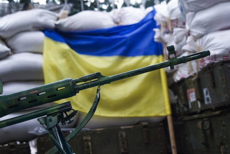 In this photo taken on Thursday, Aug. 25, 2016, a sniper rifle is placed in front of Ukrainian flag in the village of Marinka, near Donetsk, eastern Ukraine. More than 9,500 people have been killed in the fighting that began in April 2014, according to United Nations figures, but despite the carnage or the weariness of those inflicting it, there's little expectation it will actually stop anytime soon. (AP Photo/Max Black)