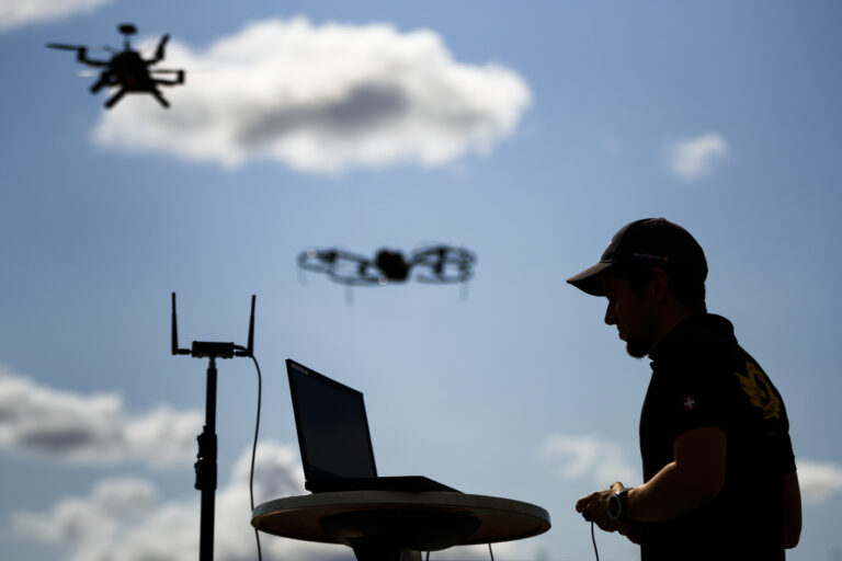 A man monitors flight data on a computer as senseFly and Intel drones fly during a media preview of 