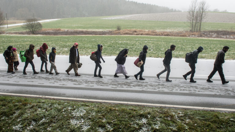 ARCHIV - Flüchtlinge gehen am 21.11.2015 an der deutsch-österreichischen Grenze nahe Wegscheid (Bayern) während eines Schneeschauers nach Deutschland. (zu dpa 