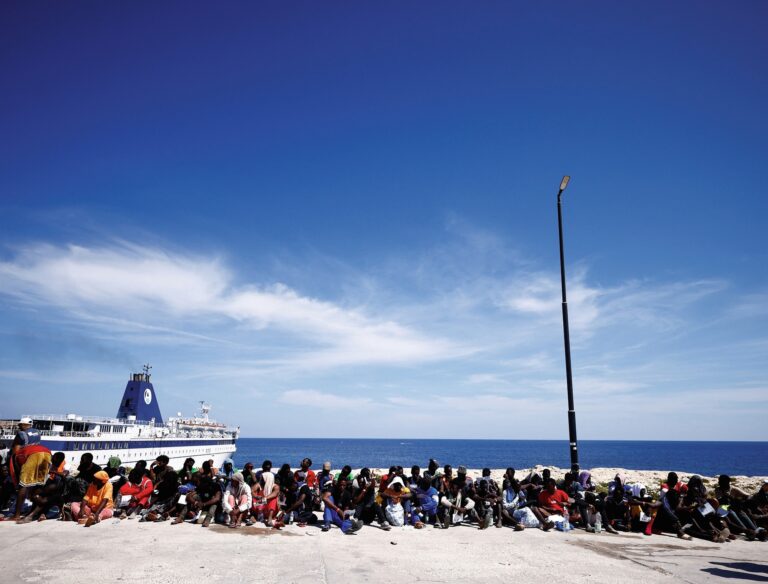 Migrants wait on the Sicilian island of Lampedusa