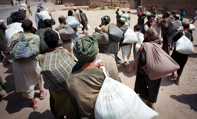 Refugees from Afghanistan leave Jalozai refugee camp headquarters near Peshawar, Pakistan, in the Afghanistan border area, after being given a modest food donation, June 25, 2001. The Pakistani government has limited aid agencies and their assistance efforts recently in camps like Jalozai. (KEYSTONE/AP Photo/David Longstreath)
