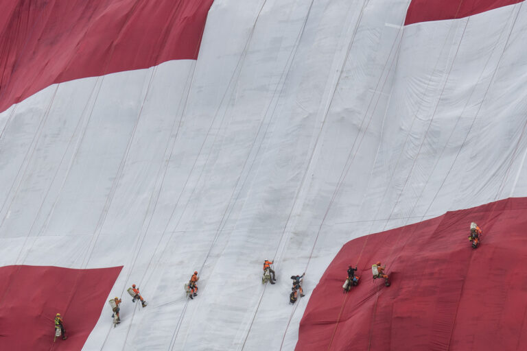 Arbeiter bewegen sich anlaesslich des Nationalfeiertags auf der ausgerollten 6400 Quadratmetern grossen Schweizerfahne am Saentis, aufgenommen am Donnerstag, 1. August 2019 auf der Schwaegalp. (KEYSTONE/Ennio Leanza)