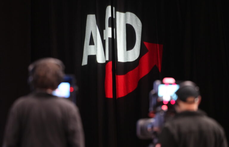 epa08036727 Two cameramen stand in front of a logo of the AfD during the convention of the German right-wing 'Alternative for Germany' party (‚Alternative fuer Deutschland' AfD) in Braunschweig, northern Germany, 01 December 2019. The AfD holds its convention in Brunswick on 30 November and 01 December. EPA/FOCKE STRANGMANN