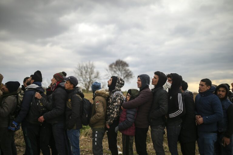 Migrants wait in a queue near Pazarkule border gate, Edirne, Turkey, at the Turkish-Greek border on Saturday, Feb. 29, 2020. Turkey's President Recep Tayyip Erdogan said his country's borders with Europe were open on Saturday, making good on a longstanding threat to let refugees into the continent as thousands of migrants gathered at the frontier with Greece. (AP Photo/Emrah Gurel)