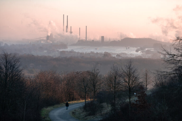 31.01.2021, Nordrhein-Westfalen, Moers: Ein Mann läuft auf einem Weg der Halde Rheinpreußen in Moers, im Hintergrund ist das Industriegebiet von Duisburg zu sehen. Foto: Fabian Strauch/dpa +++ dpa-Bildfunk +++ (KEYSTONE/DPA/Fabian Strauch)