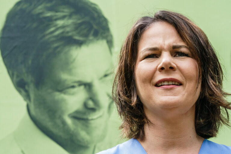 epa09367152 Green party (Die Gruenen) co-chairwoman and top candidate for the upcoming German federal elections, Annalena Baerbock talks to the media in front of a campaigning poster showing partly a photo of Green party (Die Gruenen) co-chairman Robert Habeck (not pictured) in Michendorf, Germany, 26 July 2021. On the occasion of the campaigning start for the region Brandenburg and the election district 61, Green party (Die Gruenen) co-chairwoman and top candidate for the upcoming federal elections Annalena Baerbock and the chairwoman of the Greens in Brandenburg Julia Schmidt, unveiled a campaigning poster and marked the start of the general poster campaigning. EPA/CLEMENS BILAN