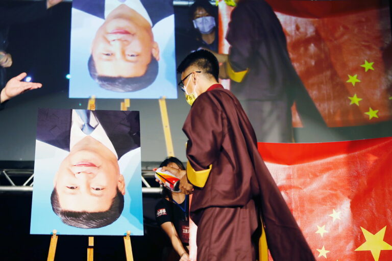 epa09499941 A Tibetan protester sprays paint at a portrait of Chinese President Xi Jinping during a joint protest joint by over 20 human rights and activist groups against Chinese political persecution and totalitarianism across the world, outside the island's parliament, Taipei, Taiwan, 01 October 2021. The protest is aimed at calling upon the Taiwanese government to review on laws regarding Hong Kong Macau, standing in solidarity with the Tibet, Uyghurs, Burmese and Hongkongers, and recognising the sovereignty of Taiwan. EPA/Daniel Ceng Shou-Yi