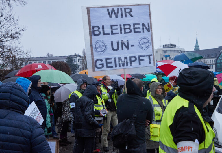27.11.2021, Hamburg: Ein Teilnehmer einer Demonstration von Corona-Impfgegnern auf dem Glockengießerwall hält ein Transparent mit den Aufschrift 