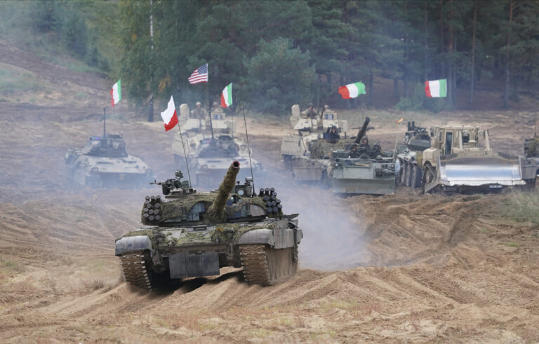 FILE - Military vehicles and tanks of Poland, Italy, Canada and United States roll during the NATO military exercises ''Namejs 2021'' at a training ground in Kadaga, Latvia, on Monday, Sept. 13, 2021. NATO responded to Russia's 2014 annexation of Ukraine's Crimean Peninsula by bolstering its forces near Russia and conducting drills on the territory of its Baltic members _ the maneuvers the Kremlin described as a security threat. (AP Photo/Roman Koksarov, File)