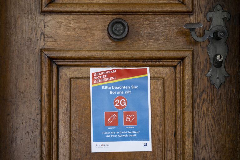 Ein Plakat an einer Eingangstuere zu einem Restaurant weist auf die 2G-Regel (geimpft oder genesen) hin, am Montag, 20. Dezember 2021, in Bern. (KEYSTONE/Peter Klaunzer)