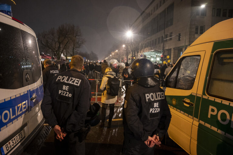 01.01.2022, Berlin: Polizisten stehen hinter einer Absperrung am Brandenburger Tor, wo sich mehrere hundert Menschen versammelt haben. Foto: Christophe Gateau/dpa +++ dpa-Bildfunk +++ (KEYSTONE/DPA/Christophe Gateau)