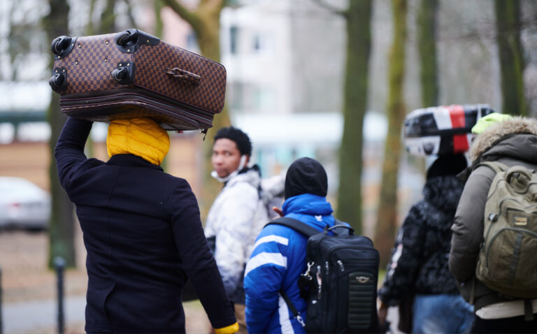 03.03.2022, Berlin: Flüchtlinge tragen ihre Koffer auf dem Kopf während sie ins Ankunftszentrum Reinickendorf gehen. Aus der Ukraine kommen immer mehr Geflüchtete. Die Kapazitäten reichen nicht mehr aus. Foto: Annette Riedl/dpa +++ dpa-Bildfunk +++ (KEYSTONE/DPA/Annette Riedl)