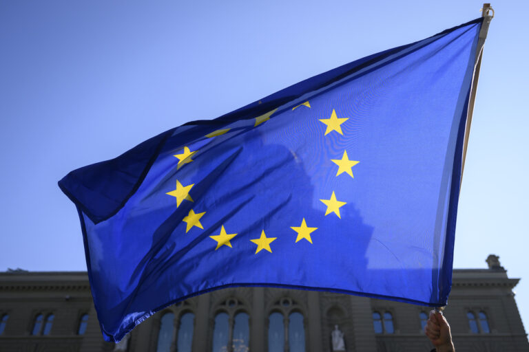 A man with an European flag protests during a demonstration against the Russian invasion of Ukraine in front of the Swiss parliament building (Bundeshaus) on the Bundesplatz in Bern, Switzerland, on Saturday, March 5, 2022. (KEYSTONE/Anthony Anex)