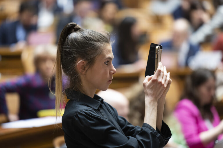 Meret Schneider, GP-ZH, filmt die Rede eines Ratskollegen, waehrend der dringlichen Debatte zum Krieg in der Ukraine, waehrend der Fruehlungssessoin der Eidgenoessischen Raete, am Mittwoch, 16. Maerz 2022, im Nationalrat in Bern. (KEYSTONE/Peter Klaunzer)