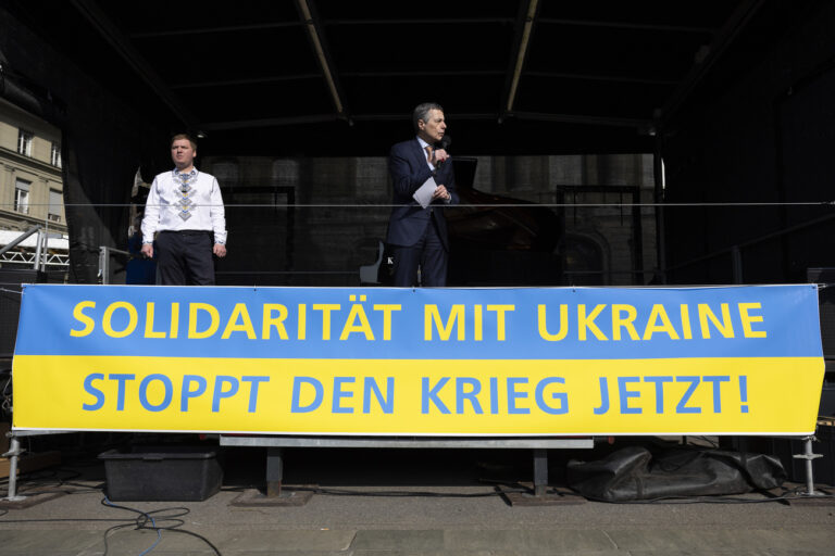 Swiss Federal President Ignazio Cassis speaks beside Artem Rybchenko, Ukrainian ambassador to Switzerland, during a demonstration against the Russian invasion of Ukraine in front of the Swiss parliament building in Bern, Switzerland, Saturday, March 19, 2022. (KEYSTONE/Peter Klaunzer)