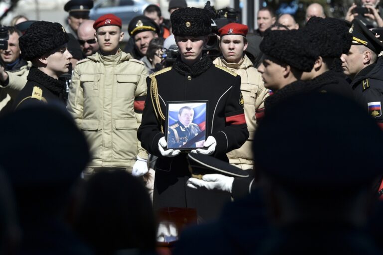 A serviceman carries the photo of Capt. Andrei Paliy, a deputy commander of Russia's Black Sea Fleet, during a farewell ceremony in Sevastopol, Crimea, Wednesday, March 23, 2022. Paliy was killed in action during the fighting with Ukrainian forces in the Sea of Azov port of Mariupol. (AP Photo)