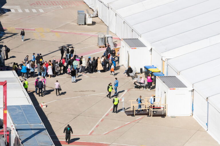 epa09855869 A view of people queuing in front of a tent at the arrival center for refugees from Ukraine at the former Tegel Airport in Berlin, Germany, 28 March 2022, during a visit by EU Commissioner Kyriakides and German Health Minister Lauterbach. EPA/CHRISTOPH SOEDER / POOL