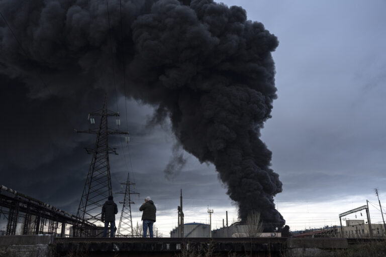 People watch as smoke rises in the air after shelling in Odessa, Ukraine, Sunday, April 3, 2022. (AP Photo/Petros Giannakouris)