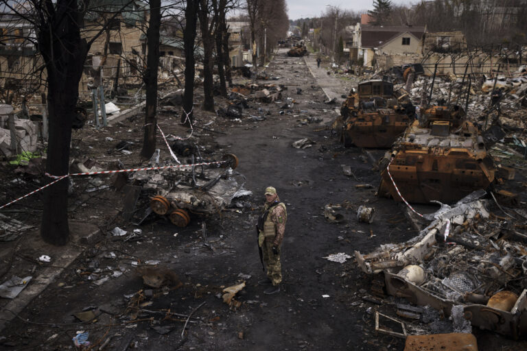 A Ukrainian serviceman stands amid destroyed Russian tanks in Bucha, on the outskirts of Kyiv, Ukraine, Wednesday, April 6, 2022. (AP Photo/Felipe Dana)