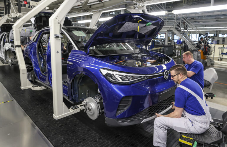 26.04.2022, Sachsen, Zwickau: Mitarbeiter montieren den Stoßfänger an einem ID.4 im Werk von Volkswagen in Zwickau. In dem Werk laufen neben den VW-Fahrzeugen auch die Fahrzeuge der Konzernmarken Audi und Seat vom Band. Die Fahrzeuge basieren auf dem Modularen Elektrobaukasten. Volkswagen hat den Standort mit rund 9000 Beschäftigten für 1,2 Milliarden Euro zur reinen Fabrik für Elektrofahrzeuge umgebaut und die Transformation zum E-Standort nun abgeschlossen. Foto: Jan Woitas/dpa +++ dpa-Bildfunk +++ (KEYSTONE/DPA/Jan Woitas)