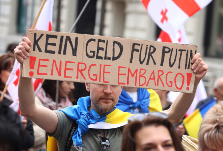 08.05.2022, Bayern, München: Ein Teilnehmer einer Kundgebung gegen den Krieg in der Ukraine hält bei einem Demonstrationszug durch die Innenstadt ein Schild mit der Aufschrift 