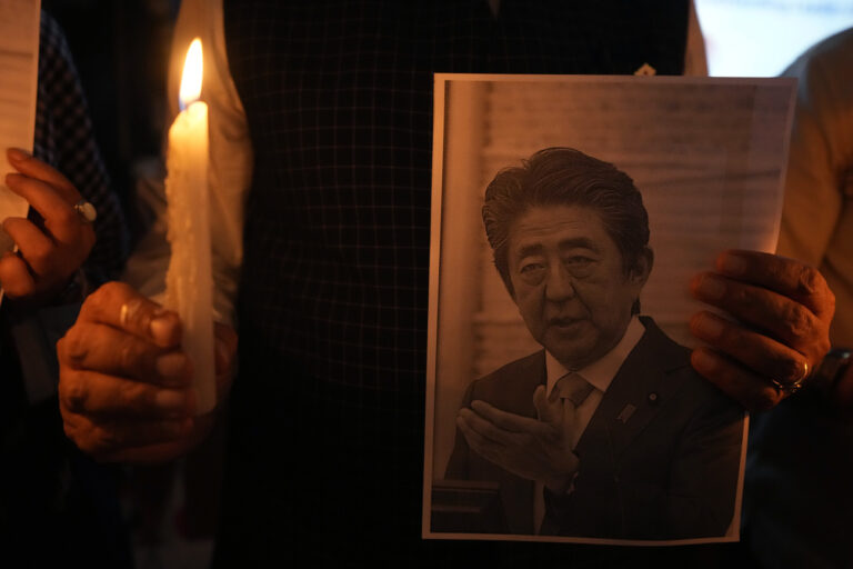 An Indian man holds a candle and photo of Japan's former Prime Minister Shinzo Abe during a prayer meeting to pay their respects at Japan Information and Study Centre in Ahmedabad, India, Saturday, July 9, 2022. Abe was shot in the Japan's western city of Nara on Friday and airlifted to a hospital but died of blood loss. (AP Photo/Ajit Solanki)