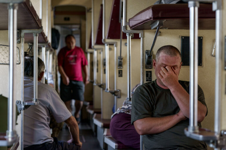 A passenger sits on an evacuation train waiting to depart from Pokrovsk, Donetsk region, eastern Ukraine, Tuesday, Aug. 2, 2022, heading west to a safer part of the country. The government issued an order to residents to leave the Donetsk region in the face of the Russian offensive as they're preparing for fall and winter and fear that many there may not have access to heating, electricity, or even clean water. (AP Photo/David Goldman)