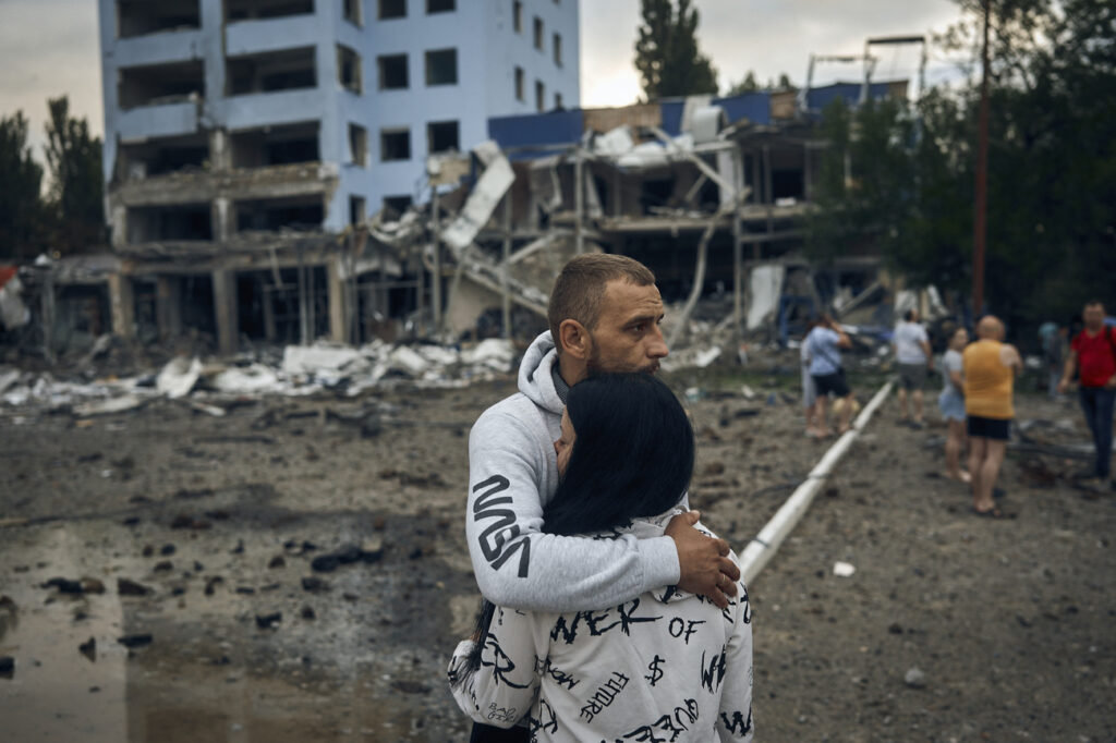 A couple reacts after the Russian shelling in Mykolaiv, Ukraine, Wednesday, Aug. 3, 2022. According local media, supermarket, high-rise buildings and pharmacy were damaged. (AP Photo/Kostiantyn Liberov)