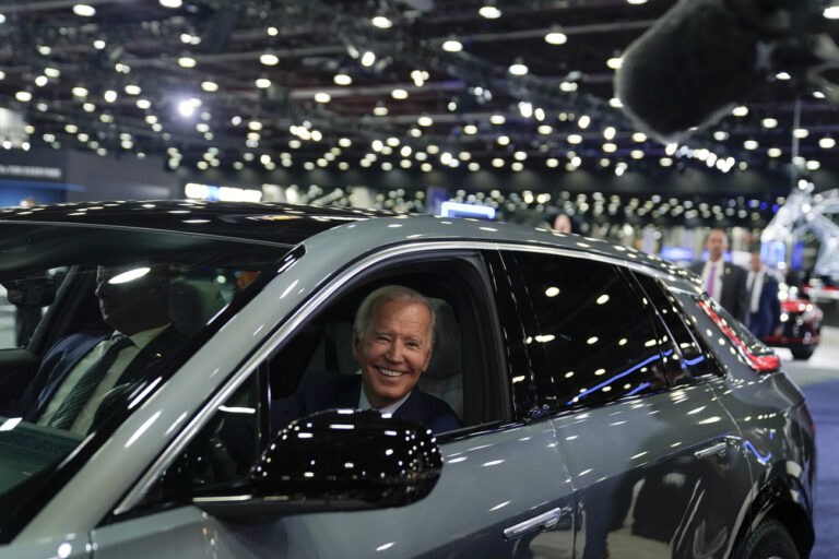 FILE - President Joe Biden drives a Cadillac Lyriq through the showroom during a tour at the Detroit Auto Show, Sept. 14, 2022, in Detroit. Biden, a self-described âÄœcar guy,'' often promises to lead by example by moving swiftly to convert the sprawling federal fleet to zero-emission electric vehicles. But efforts to help meet his ambitious climate goals by eliminating gas-powered vehicles from the federal fleet have lagged. (AP Photo/Evan Vucci, File)