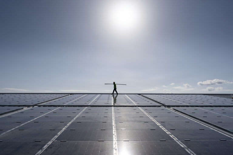 Ein Solateur der Firma IngEne traegt Elemente, um die neuen mit Solarpanels auf dem Dach der Winter und Sports World Wallisellen zu befestigen, fotografiert am Donnerstag, 6. Oktober 2022 in Wallisellen. Die Werke Versorgung Wallisellen AG hat an der Aussenfassade, dem Dach des Eisfeldes sowie der Garderoben und dem Restaurant der Sportanlage eine Gesamtflaeche von insgesamt 3'738 m2 mit Solarpanels verbaut. Diese PV-Anlage produziert bei einer Leistung von 643.4 kWp gesamthaft 650'000 kwh Energie. Ueber das Jahr gerechnet wird die Winter und Sports World Wallisellen damit zum Selbstversorger. Ueberschuesse der erneuerbaren Sonnenenergie kann die Walliseller Bevoelkerung beziehen. (KEYSTONE/Gaetan Bally)