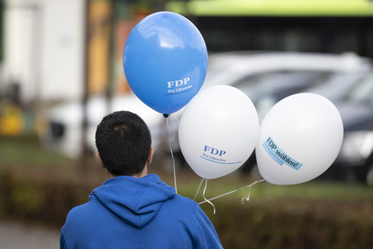 Eine Person haelt die aufblasbare Luftballons in den Farben der FDP an die Delegiertenversammlung und der Tag der FDP Die Liberalen Schweiz, am Samstag, 22. Oktober 2022 in Burgdorf. (KEYSTONE/Anthony Anex)