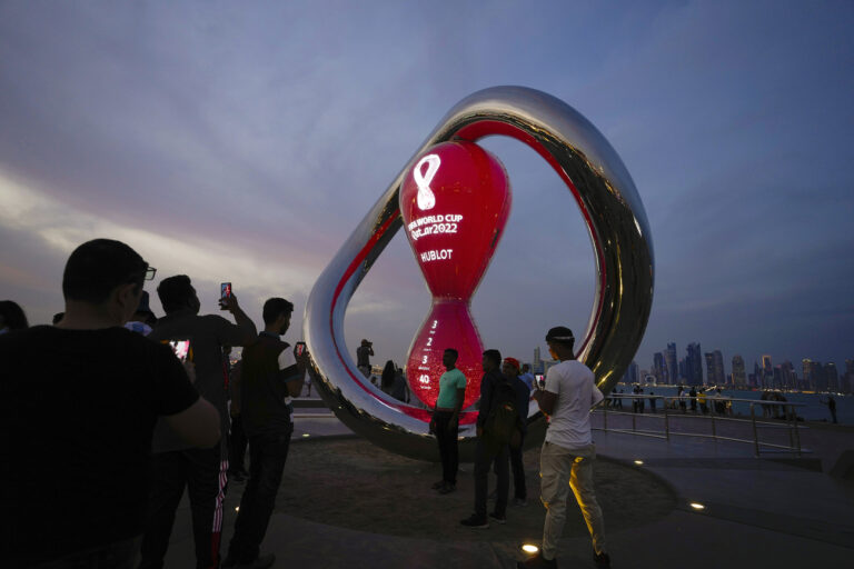 People gather around the official countdown clock showing remaining time until the kick-off of the World Cup 2022 in Doha, Qatar, Thursday, Nov. 17, 2022. Final preparations are being made for the soccer World Cup which starts on Nov. 20 when Qatar face Ecuador. (AP Photo/Hassan Ammar)