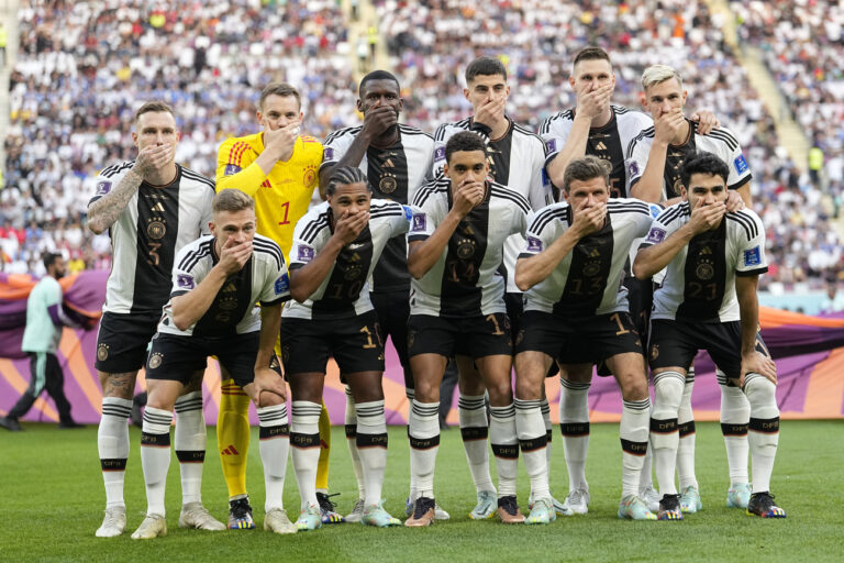 Players from Germany pose for the team photo as they cover their mouth during the World Cup group E soccer match between Germany and Japan, at the Khalifa International Stadium in Doha, Qatar, Wednesday, Nov. 23, 2022. (AP Photo/Ebrahim Noroozi)